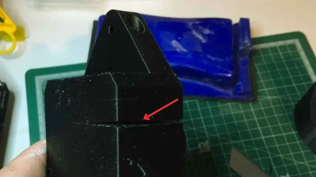 Cracked ABS 3D printed part with a point mark highlighted.