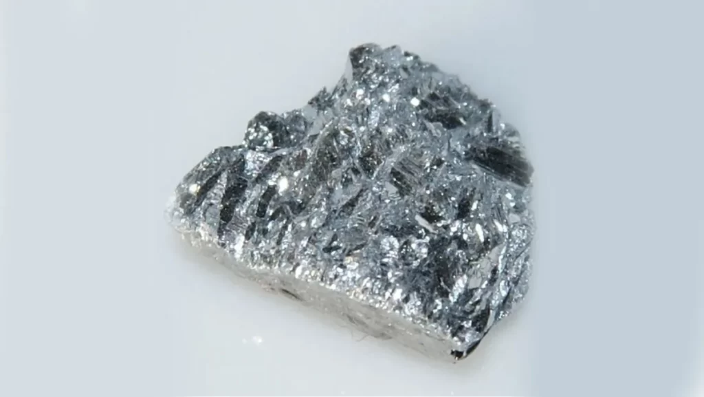 A close-up of a metallic, crystalline piece of the element antimony.