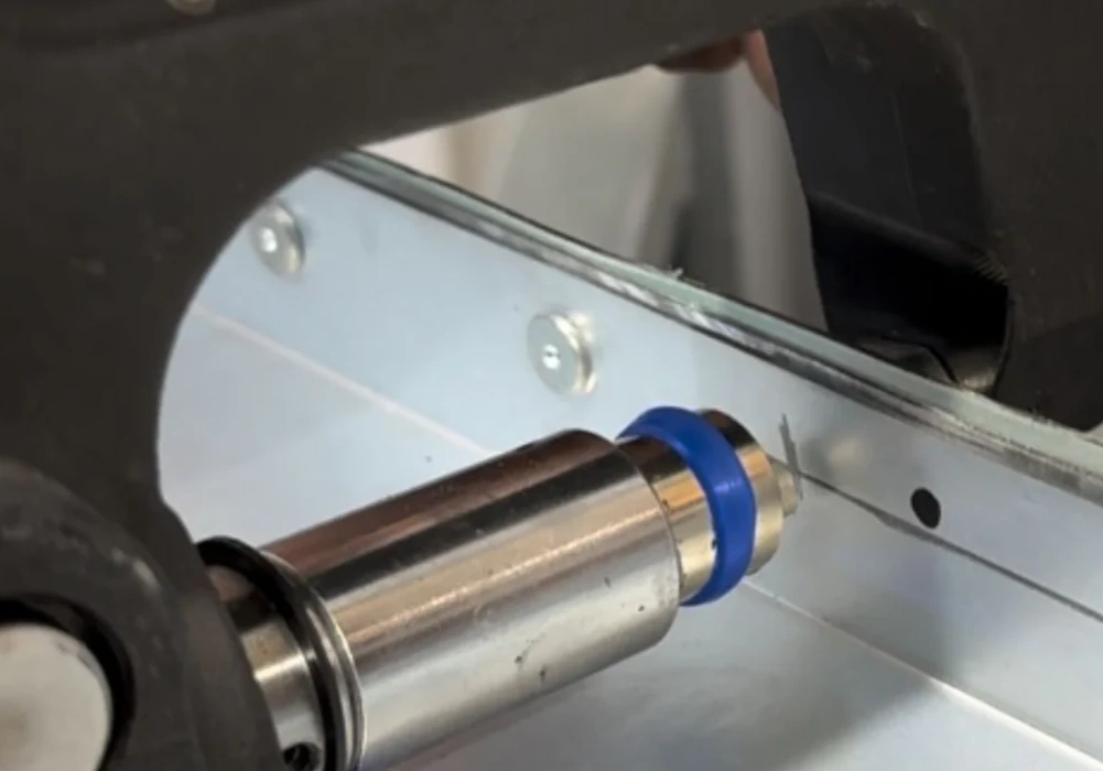 A closeup image of SPR rivets being installed into a white car body panel