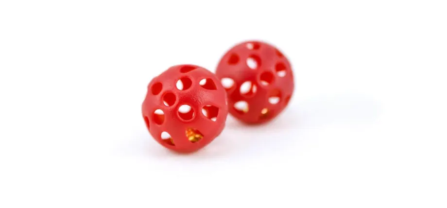 Red ball with holes and golden bell inside