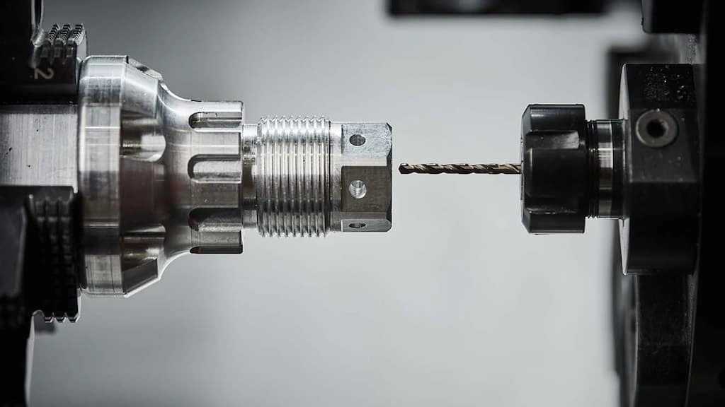 An image of the CNC turning area, a bit is about to drill the hole in the threaded part