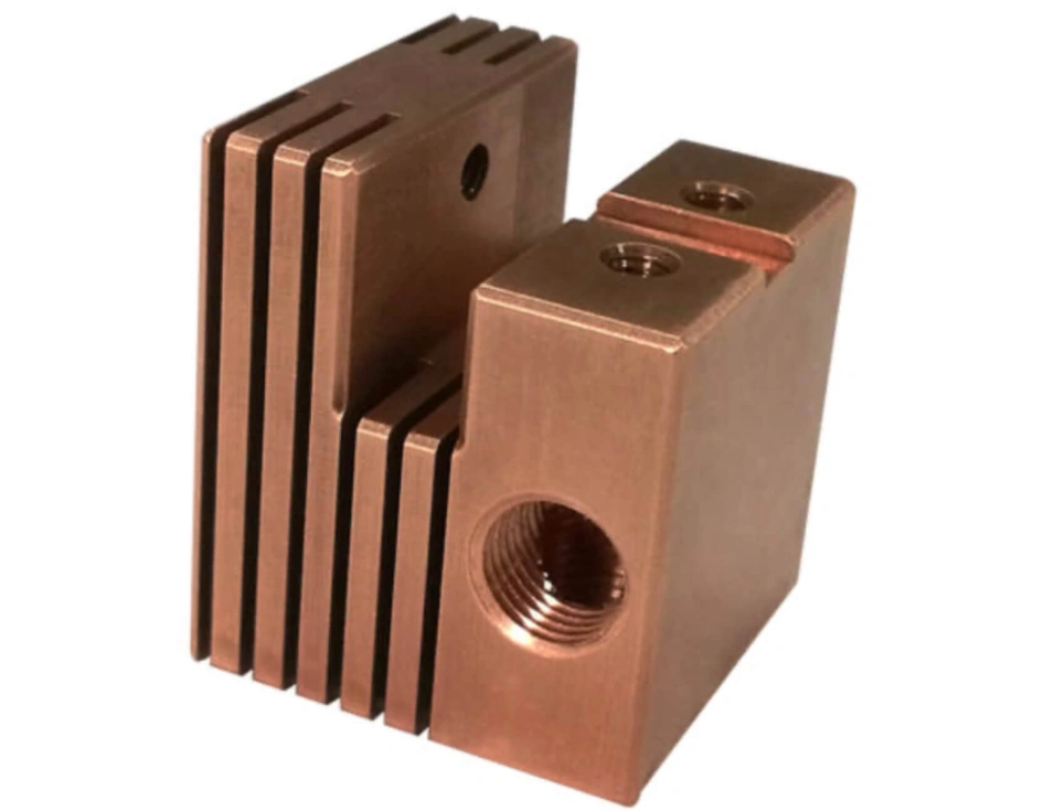 Red brass block with grooves running almost halfway along two sides featuring four threaded holes of different sizes