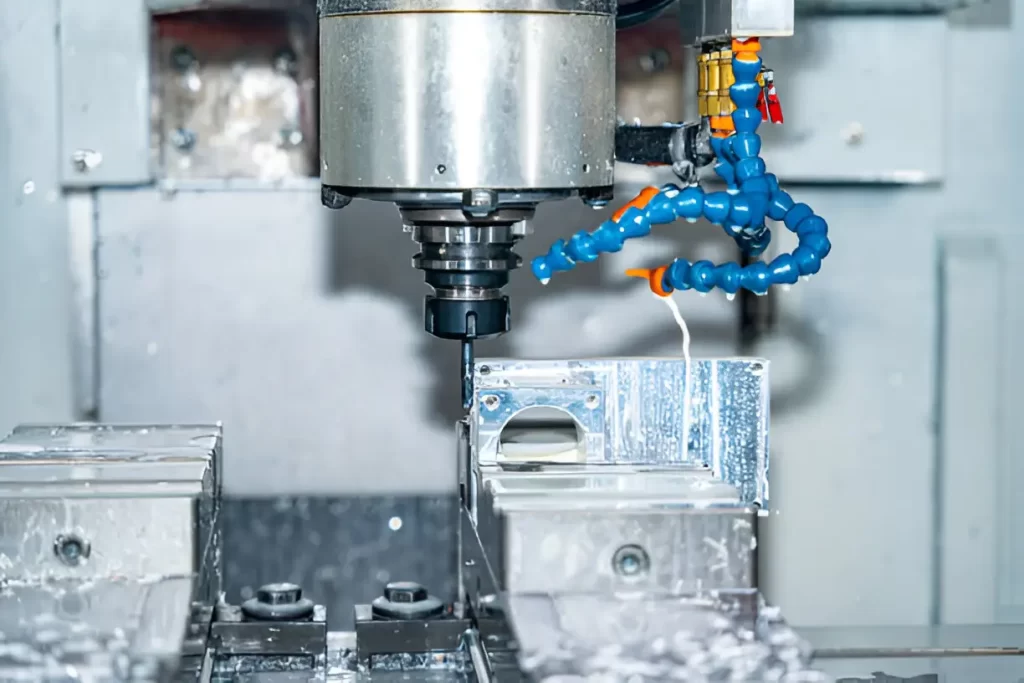 CNC milling machine working on a metal piece with coolant spraying during the process.