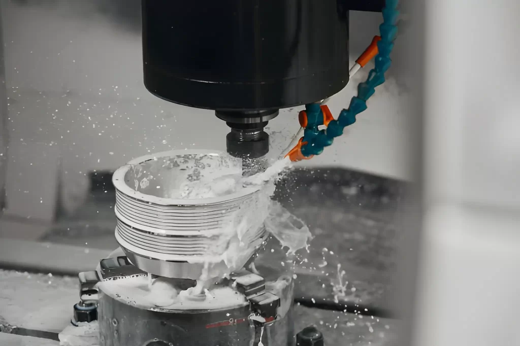 CNC milling process with coolant flowing over a metal workpiece while machining a threaded part.