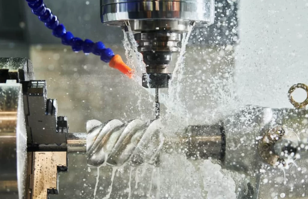 A closeup image of CNC machining process with coolant splashing on the workpiece