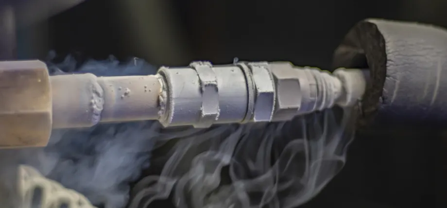 Close-up of liquid nitrogen cooling a tool during green machining of a white ceramic part in a CNC process.