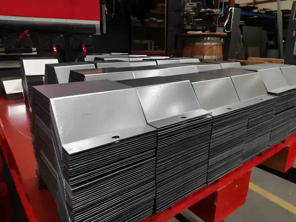 Identical sheet metal parts neatly stacked together, representing organized production.