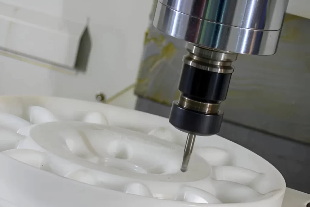 The image shows a Delrin workpiece being shaped on a CNC machine. 