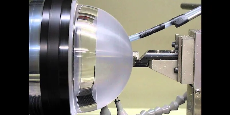 Diamond turning process on a transparent spherical lens using precision machining tools.