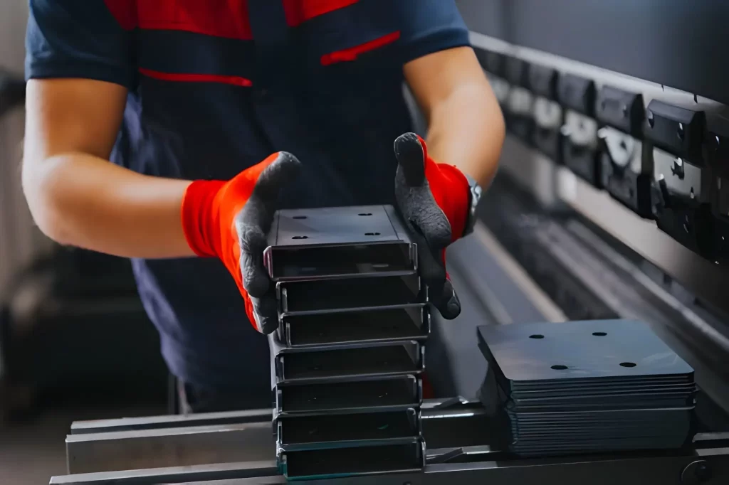 A factory worker carefully stacking metal parts on top of each other
