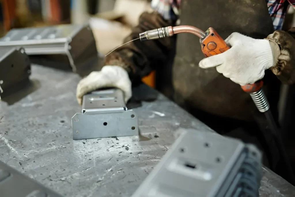 Image shows a welder gas welding a metal part.
