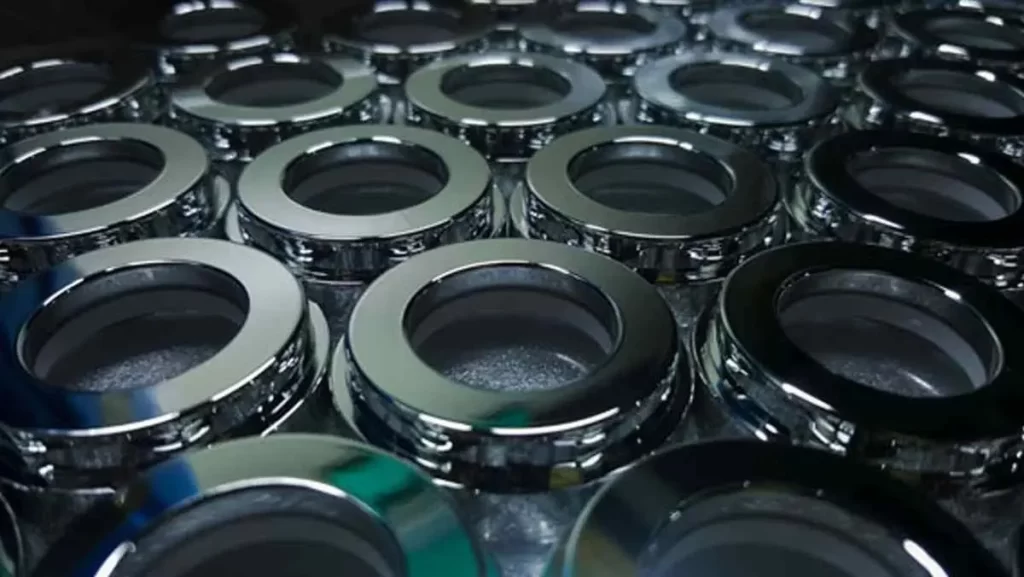 A close-up of many shiny, silver-colored ring-shaped metal components, possibly injection molded.