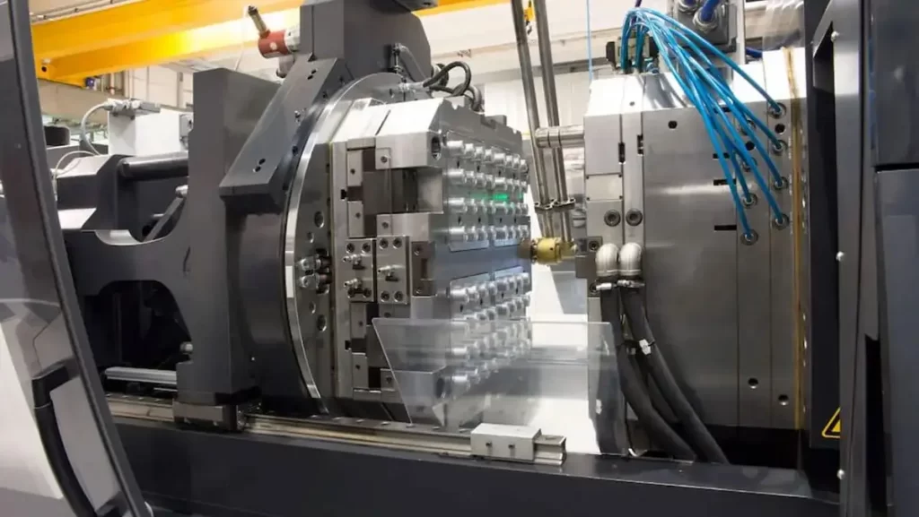 A large, industrial injection molding machine with a complex mold assembly.