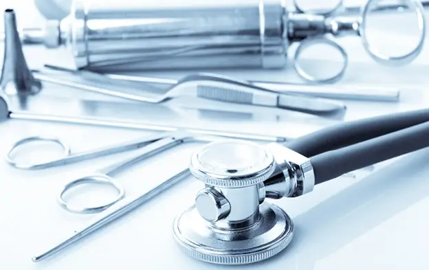 Assorted medical instruments and a stethoscope on a sterile surface.