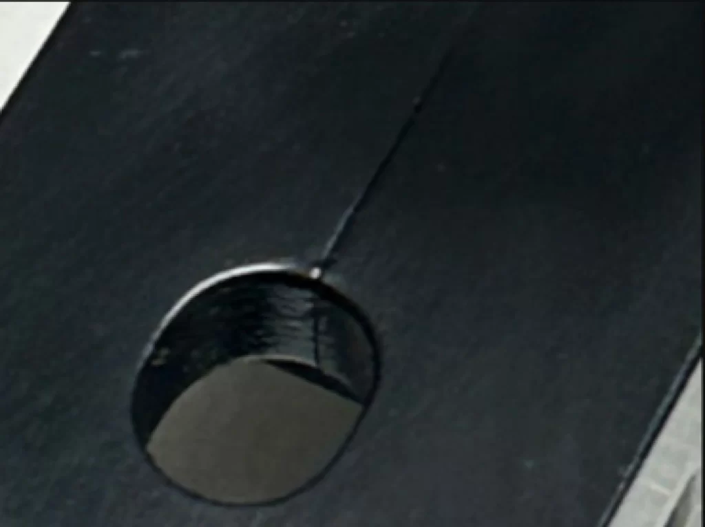 A black plastic injection molded part with a line at the middle, the parting line