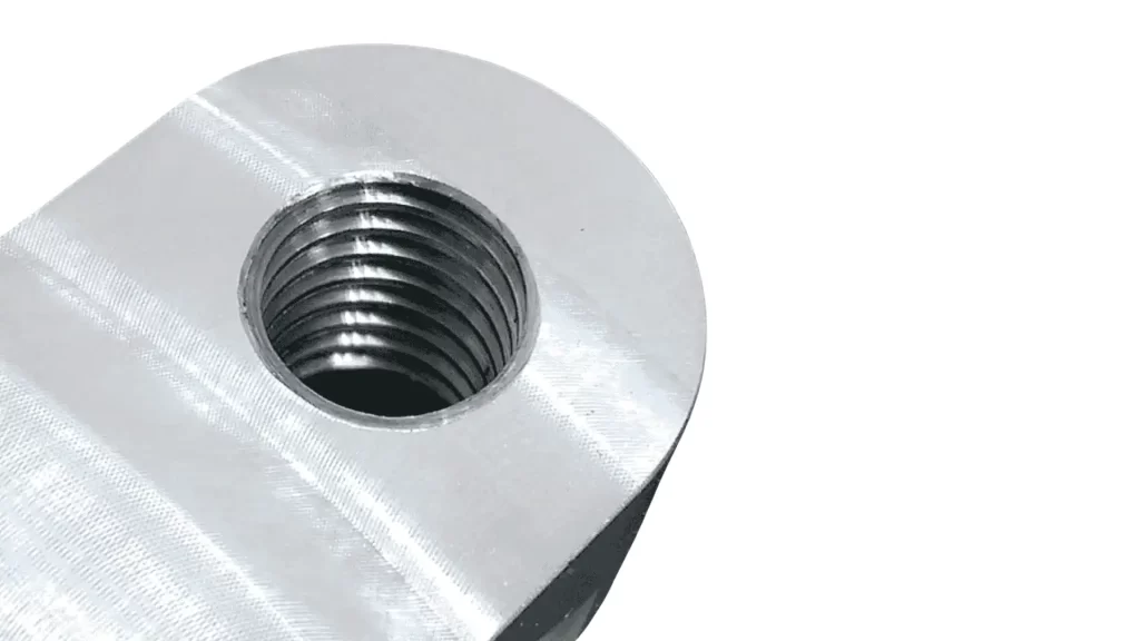 The image shows a metal part with a thread milled pattern.