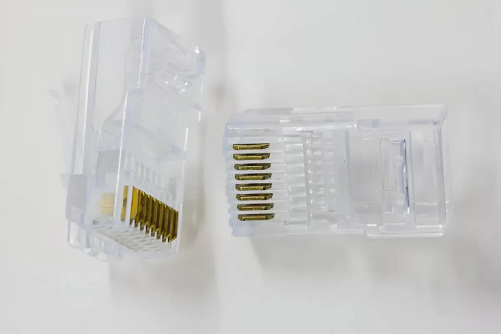 A close-up view of an RJ45 modular connector made of acrylic. The connectors are transparent and precisely molded with fine details.