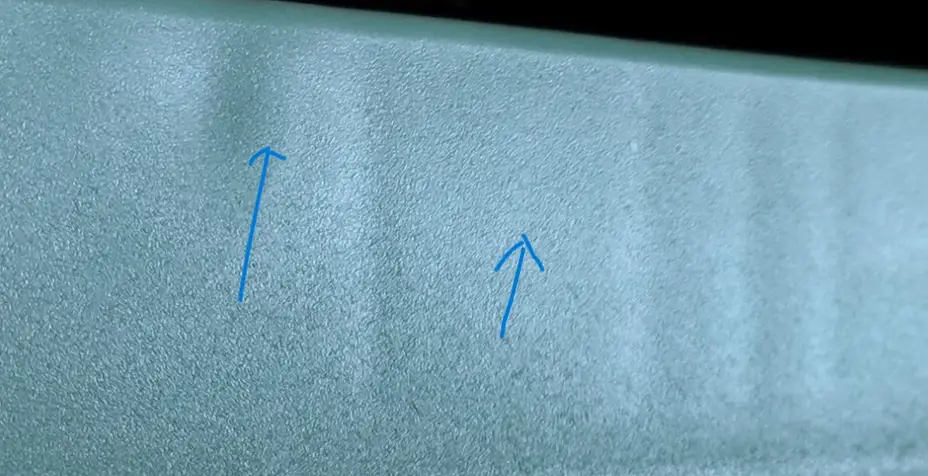 An image of a section of a plastic injection molded part with sunken areas called sink marks