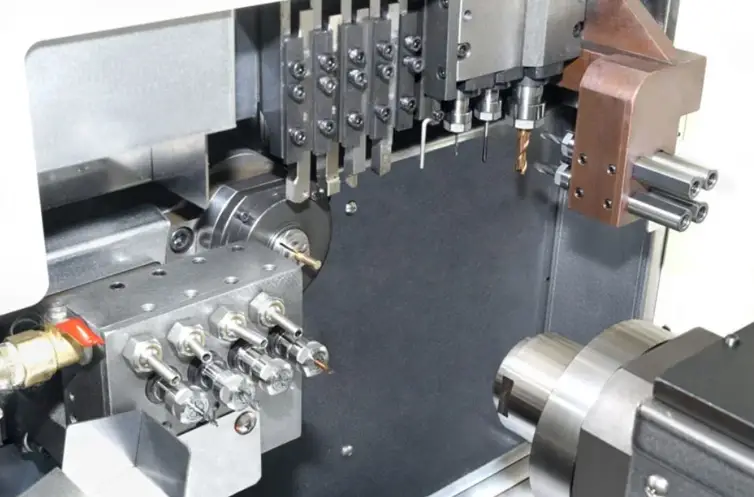 Swiss-type CNC lathe interior showing guide bushing, tool turret, and multi-axis machining setup
