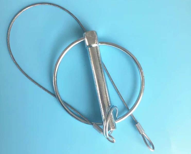 A sleek, metallic pin with an attached wire loop, set against a sky blue background