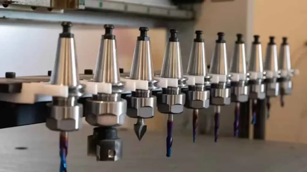 The image shows a CNC machine performing a tool switch, replacing one tool with another to continue the machining.