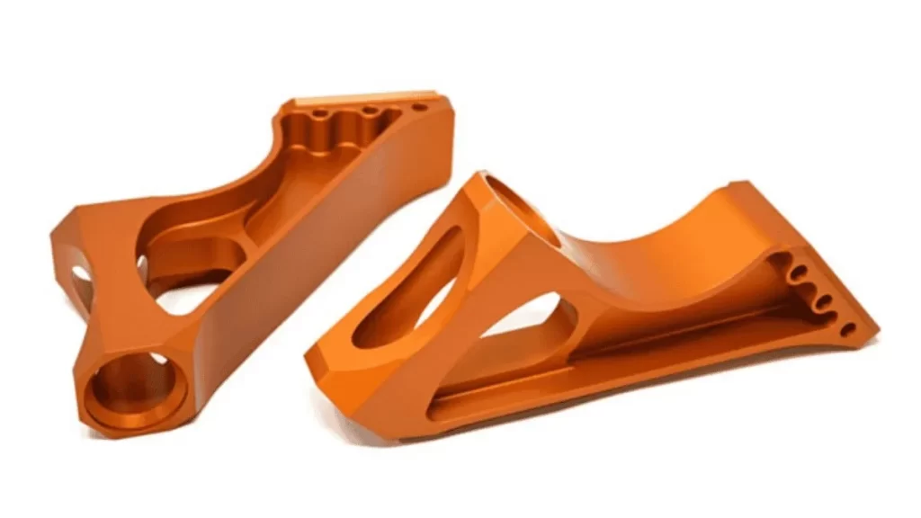 Close-up of metal parts with an orange finish from Type II anodizing.