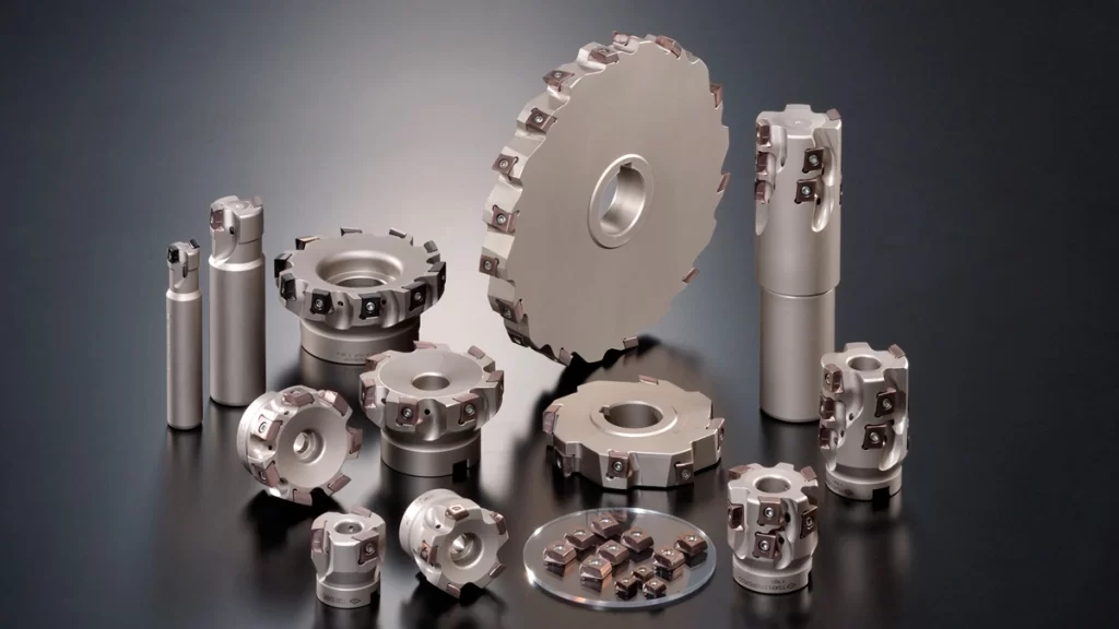 Different types of shoulder mill cutters, including face mills, end mills, disc cutters, and indexable inserts, arranged on a dark background for precision machining applications. 